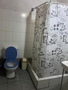 a bathroom with a blue toilet and a shower curtain at Enkanta Guest House in Trujillo +38 photos