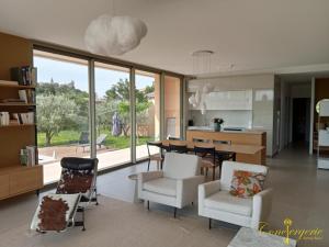 een keuken en woonkamer met een tafel en stoelen bij La villa des vignes in Castillon-du-Gard
