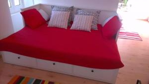 a bed with red sheets and pillows in a room at Charmantes Steinhaus mit Pool und Panoramablick in Bobovišća +14 photos