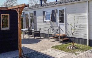 a house with chairs and a table on a patio at Lovely Home In Tzummarum With Wifi in Tzummarum