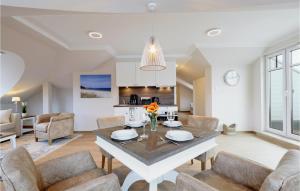 une salle à manger et un salon avec une table et des chaises dans l'établissement Baltischer Hof Apartment 68, à Boltenhagen
