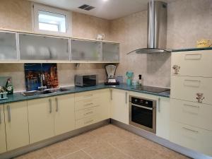 a kitchen with white cabinets and a sink at Masia Bernat in Tortosa