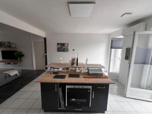 a kitchen with an island in the middle of a room at Appt ville campagne in Thiviers