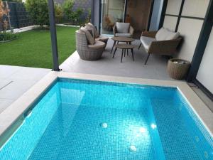 トロギールにあるUNIQUE Trogir - garden with PRIVATE heated massage POOL ONLY FOR YOUの庭園内のスイミングプール(椅子、テーブル付)