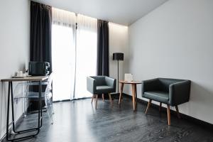 Una sala de estar con dos sillas y una mesa. en Hotel Lux Santiago, en Santiago de Compostela