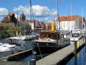 a boat is docked at a dock with other boats at Apartment Ogrody in Gdańsk