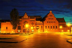 a large brick building with street lights in front of it at Apartment Ogrody in Gdańsk