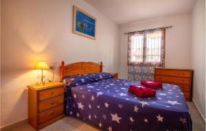 - une chambre avec un lit doté d'une couette bleue et de 2 sacs rouges dans l'établissement Cozy Apartment In San Pedro Del Pinatar, à San Pedro del Pinatar