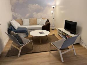 a living room with a couch and a table and chairs at Le presbytère 30 min de Beauval in Les Montils