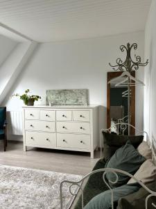 a bedroom with a white dresser and a mirror at La suite d'Anna in Rohan