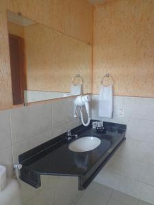 a bathroom with a sink and a mirror at Magnus Plaza Hotel in Macapá