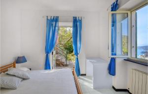 a bedroom with blue curtains and a bed and a window at 3 Bedroom Beautiful Home In Rapallo in Rapallo