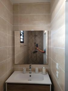 eine Person, die ein Foto von einem Waschbecken in einem Badezimmer macht in der Unterkunft La maison du bonheur in Le Lambert