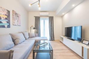 salon z kanapą i telewizorem z płaskim ekranem w obiekcie Superior Αpartment w Atenach