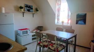 a kitchen with a table with chairs and a microwave at Apartmany u Lipno in Frymburk