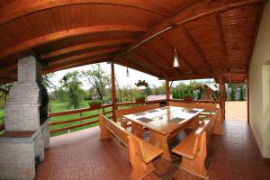 a large wooden pavilion with a table and a fireplace at Pensiunea Valea Ursului in Câmpulung