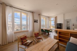 a living room with a table and chairs and windows at Grand Hôtel de Bretagne in Le Palais
