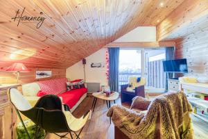 salon z czerwoną kanapą i krzesłami w obiekcie Homency - Résidence Le Kirlys w LʼAlpe-dʼHuez