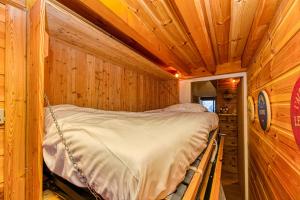 sypialnia z łóżkiem w drewnianym domku w obiekcie Homency - Résidence Le Kirlys w LʼAlpe-dʼHuez