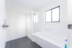 bagno bianco con doccia e finestra di Just Beachy a Island Beach Altre 20 foto