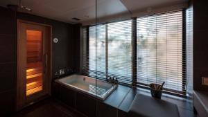 a bathroom with a bath tub and a window at NOT A HOTEL FUKUOKA in Fukuoka