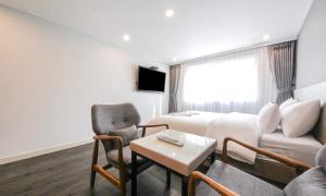 a hotel room with a bed and a couch and a table at Anyang ILLOWA Hotel in Anyang