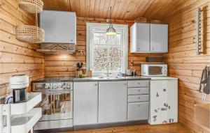 a kitchen with white appliances and wooden walls at Nice Home In Knebel With Kitchen in Knebel