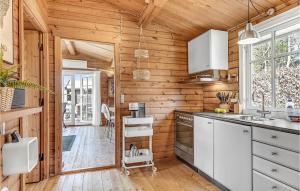 a kitchen with wooden walls and white appliances at Nice Home In Knebel With Kitchen in Knebel