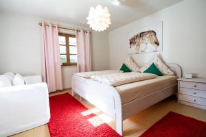 a bedroom with a white bed and a red rug at Rubi8 in Oberstdorf