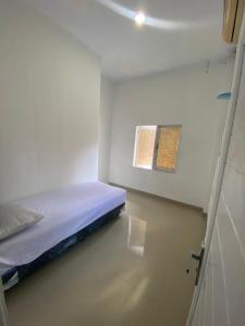 a small room with a bed and a window at Kamar Kos in Delitua
