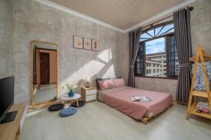 顺化KLy Apartment Hotel的卧室设有粉红色的床和大窗户