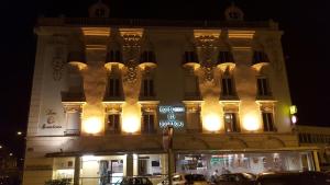 un bâtiment éclairé avec un panneau indiquant la rue devant lui dans l'établissement Logis Hotel des Bourbons, à Montluçon