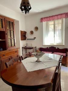 a dining room with a wooden table and chairs at Belvedere da Fernanda in Fontechiari +26 photos