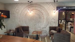 un restaurant doté d'un grand mur en pierre avec des chaises et des tables dans l'établissement Logis Hotel des Bourbons, à Montluçon