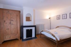 a bedroom with a bed and a fireplace at Cabana & L'Auberge Beaujolaise - Maison de Ville in Ouroux