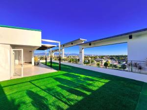 a white house with green grass on the balcony at D' Elmer's Place Hotel in Tuguegarao City