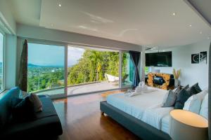 a bedroom with a large bed and a large window at Villa Beyond-Namaste 16 Bedroom Fully Staffed Seaview Villa in Ban Thalat Choeng Thale