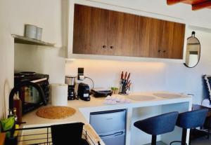 a kitchen with a counter and some blue chairs at Argalios apartment in Serifos Chora