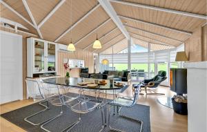 a kitchen and living room with a table and chairs at Holiday Home Skovridervænget Rudkøbing Xi in Spodsbjerg