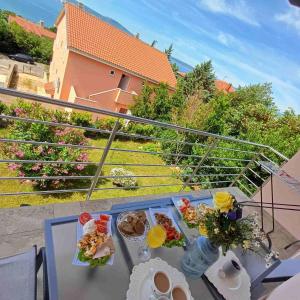 une table avec de la nourriture sur un balcon dans l'établissement LIGHTHOUSE, à Novi Vinodolski