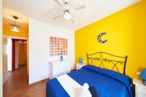 a bedroom with a blue bed and yellow walls at Sirius in La Isleta del Moro