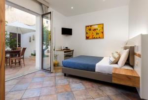 a bedroom with a bed and a sliding glass door at Le Margherite in San Vito lo Capo