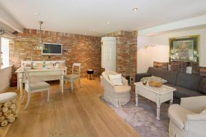 a living room with a couch and a table at Luxuriöses Apartment in Reetdachhaus in Tinnum