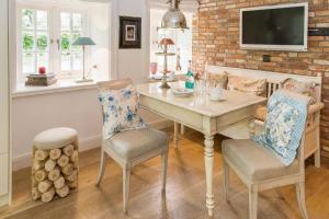 a dining room with a table and two chairs at Luxuriöses Apartment in Reetdachhaus in Tinnum +13 photos