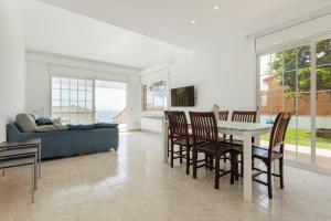 a living room with a table and chairs and a couch at Villa Grau in Canet de Mar