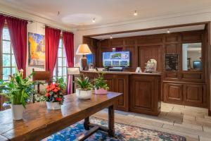 a lobby with a desk with plants on it at Demeures & Châteaux - Hôtel Greuze & Spa Tournus in Tournus