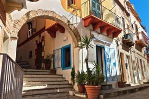 カルロフォルテにあるTramonto sul mare a Carloforteの鉢植えと階段のある建物のアーチ道