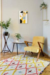 a living room with a chair and a table at Kunstvolles Apartment im Zentrum mit Balkon und Parkplatz in Graz