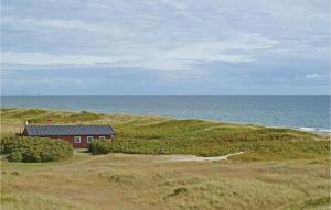 una casa roja en una colina cerca del océano en Holiday Home Gl Fyrvej, en Skagen