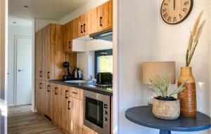 a kitchen with a clock on the wall and a table at Stunning Home In Heinkenszand With Wifi in Heinkensand